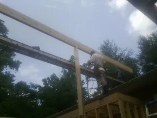Carpenter setting a ridge beam over a new addition frame — Ice Dam Removal by Roofing Brothers in Little York