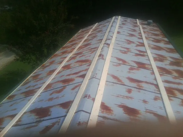 Rusted metal roof panels with new wood purlins before replacement — Storm Damage Roof Repair in Little York by Roofing Brothers